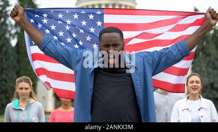 Gereizte schwarzer Mann die amerikanische Flagge, anti-rassistische Rallye, uns Migranten Krise Stockfoto