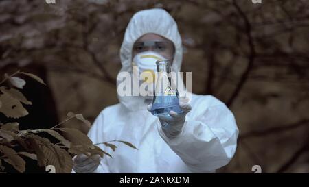 Wissenschaftlerin mit Reagenzglas radioaktive Wasser geprägt Gift, Biohazard Stockfoto