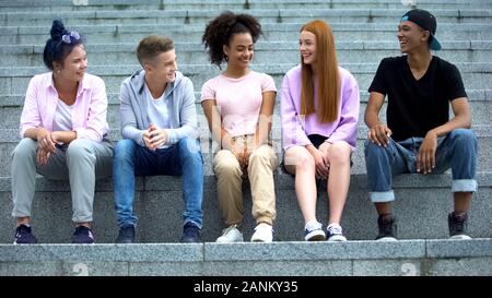 Gruppe von Multiethnischen junge Leute sitzen auf Akademie Treppen, Freizeit, Spaß Stockfoto
