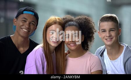 Jungen multiethnischen Freunde umarmen und lächelnd Kamera, High School Mitschüler Stockfoto