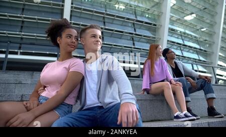 Zwei gemischtrassiges paar Jugendliche sitzen Treppen im Freien, romantische Jugend Stockfoto
