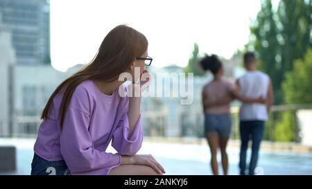 Einsame weibliche teenager Betrachten glücklich liebend Paar vorbei auf der Straße Stockfoto