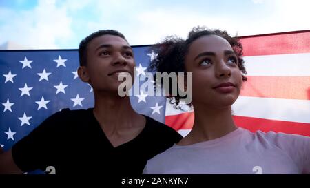 Froh, afro-amerikanische teen Paar winkenden USA-Flagge, feiert Nationalfeiertag Stockfoto