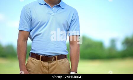 Athletischen männlichen Golf Spieler in Sportkleidung auf Kamera am Kurs Posing, Elite hobby Stockfoto
