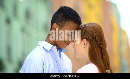 Multiethnischen teen Paar Berührung der Stirn in die Augen schauen, mit Liebe, Romantik Stockfoto