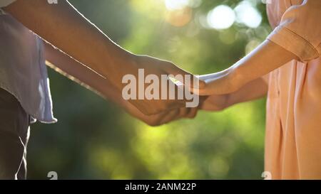 Nahaufnahme von Mixed-race Liebhaber Hände halten in Park, romantische Beziehung Stockfoto