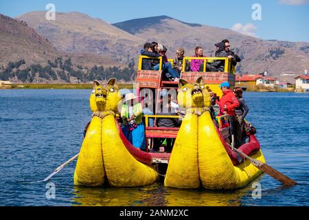 Totora reed Boot Touristen, die schwimmenden Inseln der Uros, Titicacasee, Puno, Peru Stockfoto