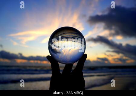 Wunderschöne Wolken bei Sonnenaufgang, die durch einen Linsenkugel am Fort Lauderdale Beach, Florida, USA, erfasst wurden Stockfoto
