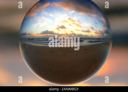 Wunderschöne Wolken bei Sonnenaufgang, die durch einen Linsenkugel am Fort Lauderdale Beach, Florida, USA, erfasst wurden Stockfoto
