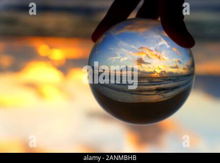 Wunderschöne Wolken bei Sonnenaufgang, die durch einen Linsenkugel am Fort Lauderdale Beach, Florida, USA, erfasst wurden Stockfoto
