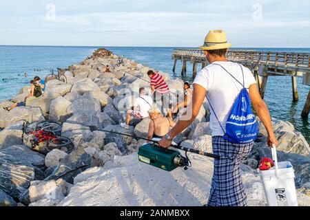 Miami Beach Florida, Atlantischer Ozean, Wasser, Steg, Wellenbrecher, Felsen, Angeln gehen, hispanischer Mann Männer männlich, FL100815007 Stockfoto