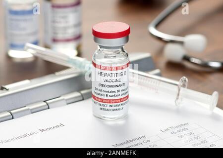 Hepatitis B-Impfstoffs auf der Arzt Schreibtisch mit Impfpass, Spritze und Stethoskop. Stockfoto