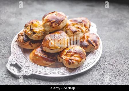 In der Nähe von süßen hausgemachten Brötchen mit gesalzen Karamell und Muttern an der Platte. Stockfoto