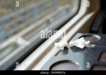 Zerknittertes Papier Servietten liegen auf einem Tisch am Fenster im Zug Stockfoto