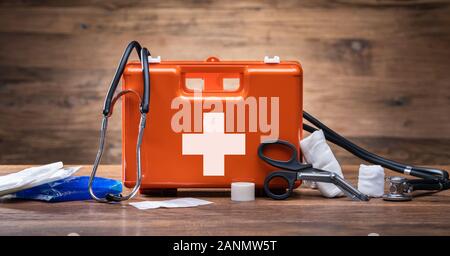 Erste Hilfe Kit mit medizinischen Geräten auf hölzernen Hintergrund Stockfoto