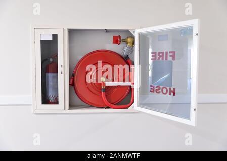 Schlauchwinde und Feuerlöscher im Hotelflur Stockfoto