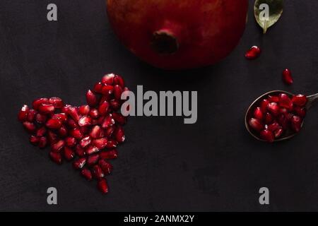 Herzform durch Granatapfel Samen in dunklen Landschaft. Stockfoto