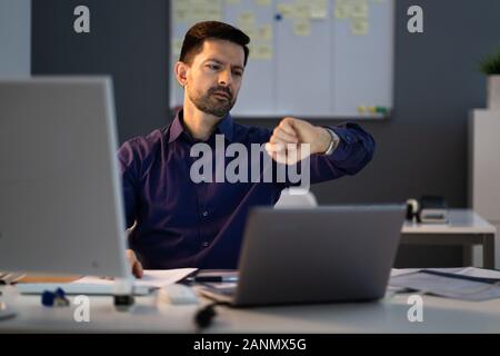 Geschäftsmann zu beobachten, während der Arbeit spät im Büro suchen Stockfoto