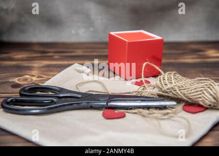 Schere, Regelgewinde, und einem Geschenkkarton liegen auf Kraftpapier Stockfoto