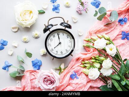 Blumen Komposition. Rahmen aus verschiedenen Blumen und Eukalyptus, Zweige und Wecker auf weißem Hintergrund. Flach, Ansicht von oben, kopieren Raum Stockfoto