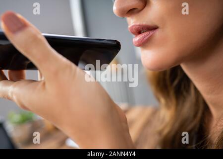 Nahaufnahme einer Frau mit Voice Assistant auf Handys Stockfoto