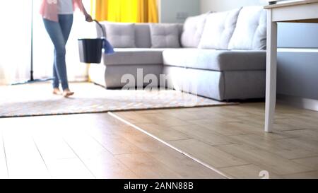 Barefoot girl Walking mit Schaufel und Mop, Werben von Haus Reinigung Stockfoto