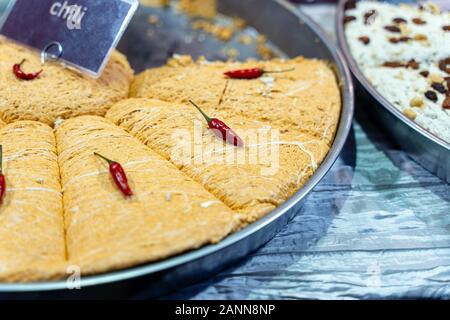 Platte aus traditionellem Nahen Osten lecker geschnittener Halva auf Holzbrett. Iraner handgemacht süß mit würzigen Chili Pfeffer. Stockfoto