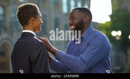 Afrikanischer Mann sehr stolz auf die jungen Sohn in Prom, College Graduation aufgeregt Stockfoto