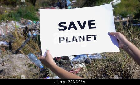 Speichern planet Phrase auf Karton in die Hände gegen Deponie Hintergrund, Ökologie Stockfoto