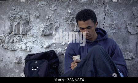 Afro-amerikanische Obdachlose Teenager an Geld suchen, Spende an Armen, Hilfe Stockfoto