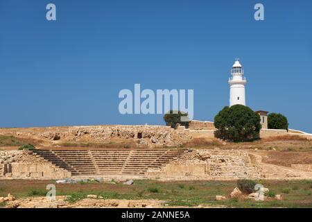 Der Blick auf den zentralen Platz (Agora) der alten Stadt von Nea Pafos mit Theater Odeun und Leuchtturm im Hintergrund. Paphos Archäologischen Park. Stockfoto