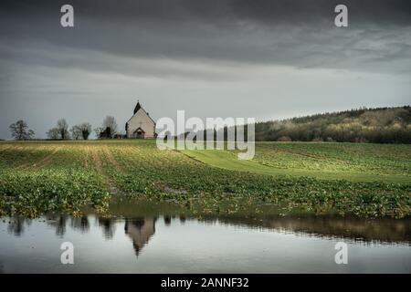 ST Huberts Chapel in Idsworth Hampshire, die nach Regen in Wasser reflektiert wird, eine typische alte englische Kirche Stockfoto