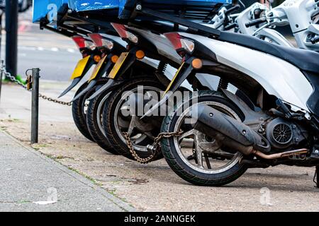 Die Hinterräder des Pizza Delivery roller Chain sind mit einer anti-Diebstahl-Kette-gesperrten Image Stockfoto