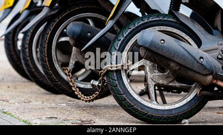 Die Hinterräder des Pizza Delivery roller Chain sind mit einer anti-Diebstahl-Kette-gesperrten Image Stockfoto