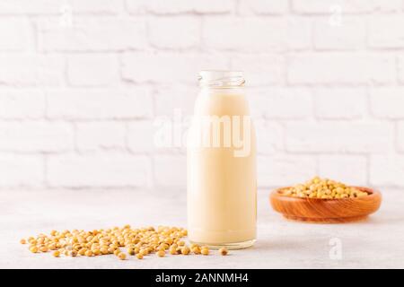 Eine Flasche Soja Milch und Soja Bohnen auf einem hellen Hintergrund. Stockfoto
