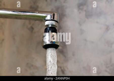 Belüftungsdüse am Wasserhahn Mixer mit drehbaren Kopf. Eine Nahaufnahme eines eingefrorenen Moment fließt aus dem Leitungswasser. Stockfoto