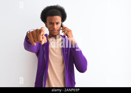 Junge afrikanische amerikanische Mann auf dem Smartphone stehend über isoliert weißer Hintergrund zeigt mit dem Finger auf die Kamera und an Sie, Hand, Zeichen, pos Stockfoto