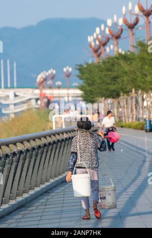 Eine Frau mit zwei großen Eimer Wasser auf ihre Schulter, abgerufen aus dem Xi Fluss, Zhaoqing, Guangdong, in China Stockfoto