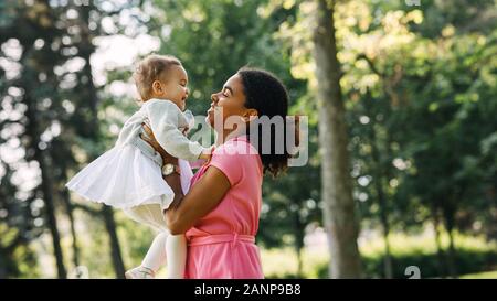 Mutter und Tochter Spaß Ausgabe Zeit zusammen im Park. Frau hob ihre Tochter. Stockfoto