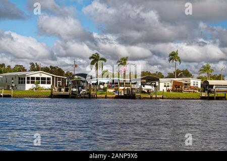 Hergestellte Häuser, Waterfront, Docks, Boote auf Aufzüge, Palmen, Gemeinschaft, Gehäuse, Orange River, Fort Myers, FL, Florida; Winter; horizontal Stockfoto