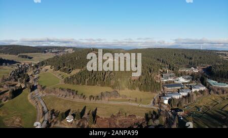 Kleine Stadt und Hügel mit Wald am See im Schwarzwald Stockfoto