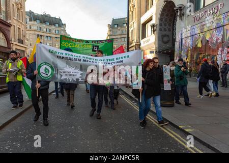 Oxford Circus, London. Januar 2020. protestmarsch im Oxford Circus mit Spruchbändern mit der Aufschrift „KAPITALISMUS BEDEUTET AUSSTERBEN“ und „ERDSTREIK NÖRDLICH DES FLUSSES“; Teilnehmer tragen grüne Marshallwesten; kommerzieller Hintergrund in der Hauptstraße einschließlich TOPSHOP sichtbarer Umweltaktivist-Gruppe Earth Strike UK protestiert am Oxford Circus. Penelope Barritt/Alamy Live News Stockfoto