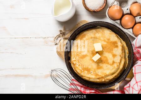 Crepes oder dünne Pfannkuchen in der Pfanne mit Zutaten zum Kochen. Stockfoto