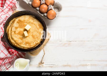 Crepes oder dünne Pfannkuchen in der Pfanne mit Zutaten zum Kochen. Stockfoto