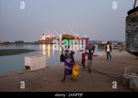 Bissau, Republik Guinea-Bissau - 11. Februar 2018: eine Mutter mit zwei Kindern bei der Ankunft im Hafen der Stadt Bissau, Guinea-Bissau, West A Stockfoto
