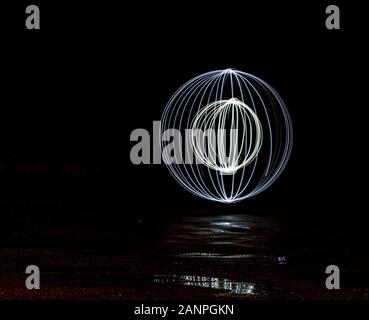 Runde Kugel Spiralen durch Malen mit Licht in der Dunkelheit mit Reflexionen erstellt Stockfoto