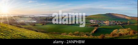 Panoramablick vom Gipfel des untergehenden Sonne im nebligen Tal in Dorset, Großbritannien Stockfoto