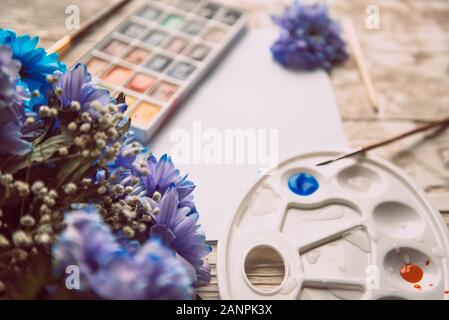 Palette mit Aquarellfarben, Pinsel und Papier für ein Wasser Farbe auf Holz- Hintergrund, aus der Nähe. Flach, Frühling Hintergrund mit kopieren. Stockfoto