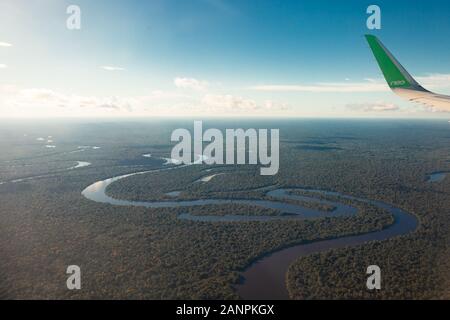 Blick auf den Fluss Amazonas vom Flugzeug aus, dichten tropischen Wald, Spiegelbild im Wasser. Stockfoto