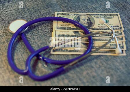 Prüfung der finanziellen Zustand: Stethoskop auf Stapel von US-Dollarnoten auf grauem Hintergrund. Bezahlt Medizin Konzept. getönt. Stockfoto